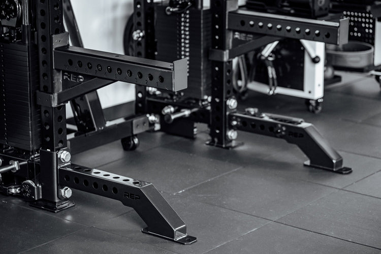 Close-up of a weightlifting rack in a gym setting with Front Foot Extension Pair 2.0