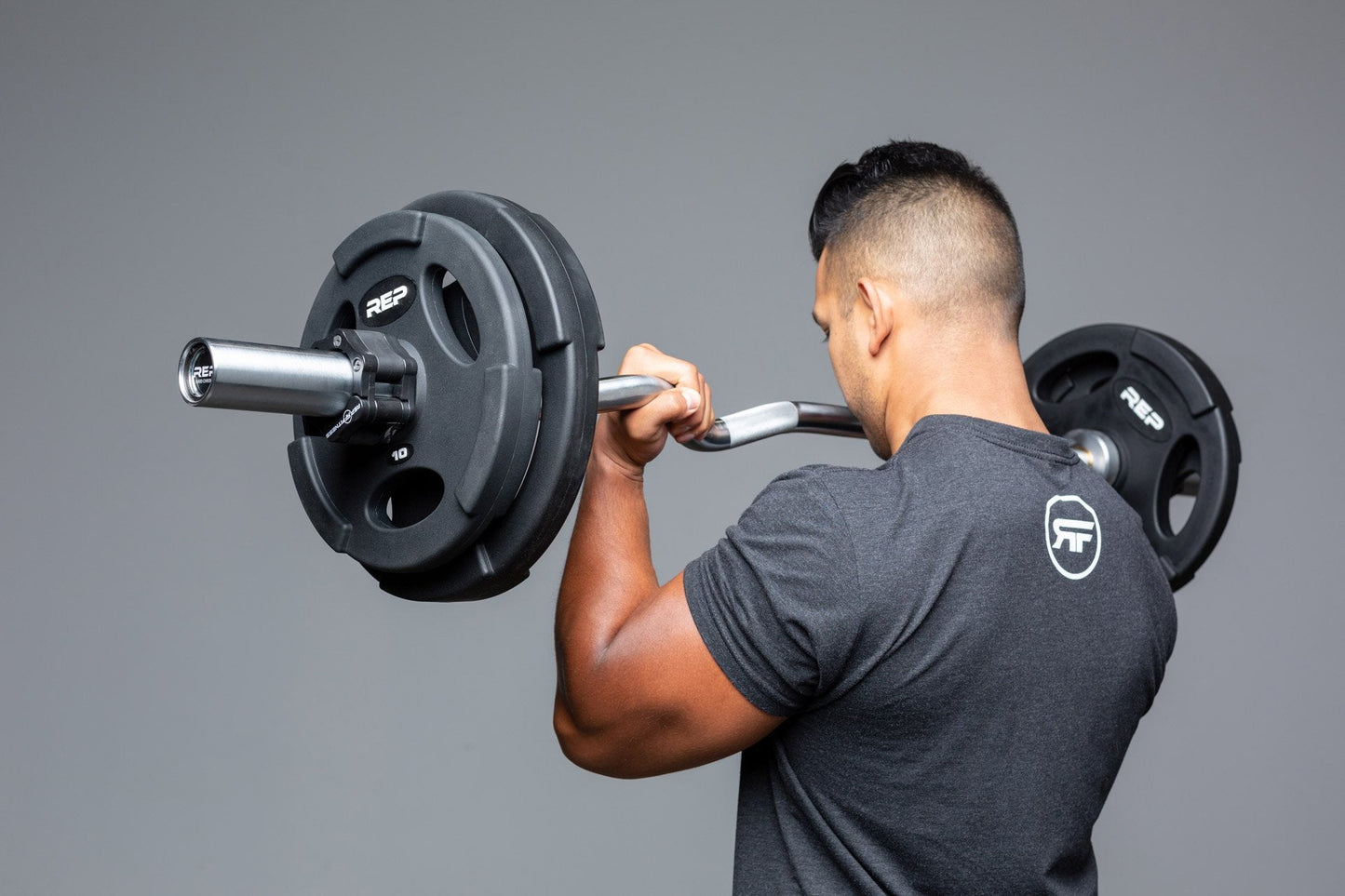 Lifter using loaded curl bar for bicep curls.